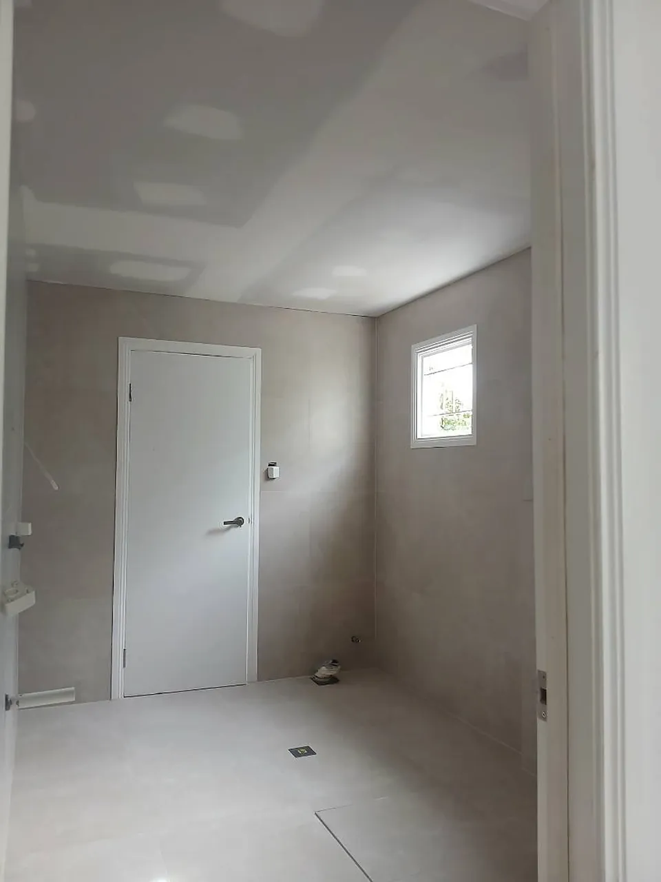 Bathroom with prepared ceiling patches, door and window, before painting